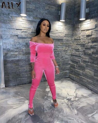 femme debout portant une combinaison velours femme de couleurs rose.