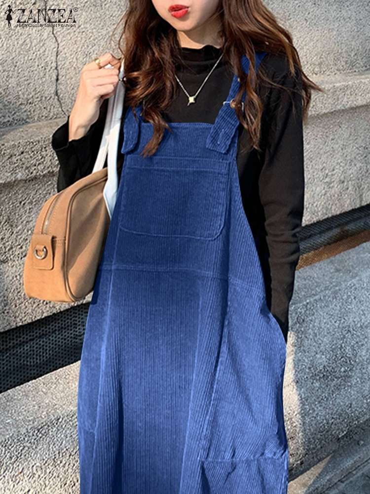 femme marchant dans la rue et portant une Robe salopette en velours côtelé femme de couleurs bleu avec un sac à main marron