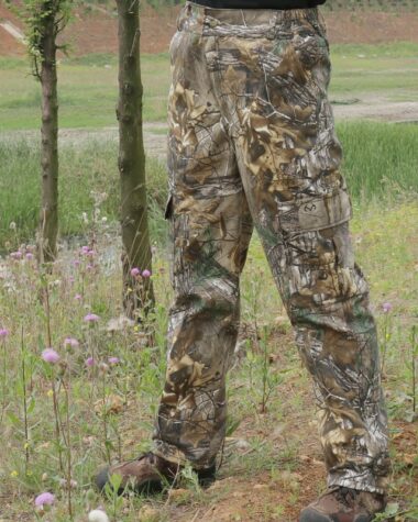 Photo d'une salopette de chasse de camouflage portée par un homme dans une prairie