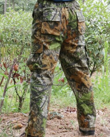 Photo d'une salopette pantalon de chasse portée par un homme avec fond de végétation
