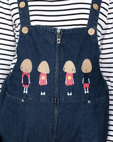On voit le haut d'une salopette en jean qui est décorée de quatre petits enfants, personnages, de dos. C'est une famille. La salopette est présentée sur une marinière.