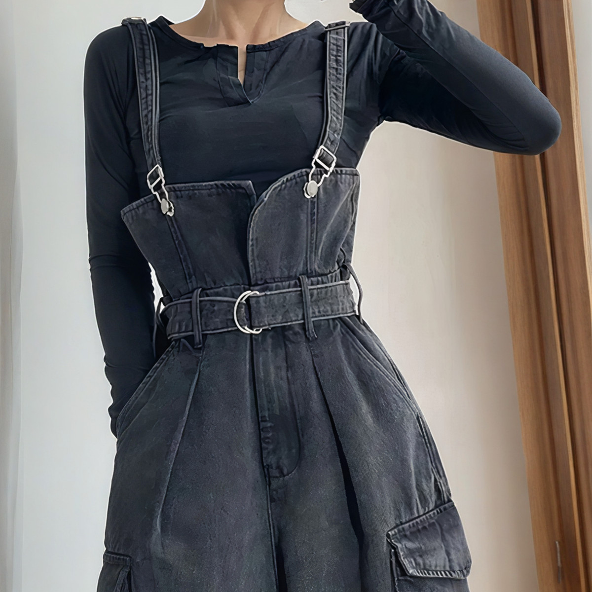 Salopette noire femme taille haute en jean avec ceinture intégrée et poches latérales.