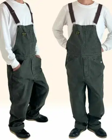 Salopette travail vintage homme de couleur kaki en coton avec bretelle marron portée par un jeune homme vêtu d'un t-shirt blanc.