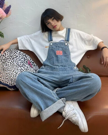 Salopette femme en jean confort absolu avec une coupe loose et son denim délavée portée par une jeune fille brune.