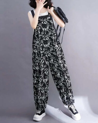Salopette tissu doux au style unique noire avec imprimé lettre de l'alphabet portée par une jeune femme caucasienne